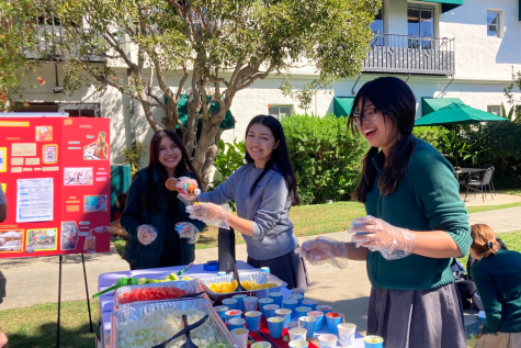 Hermanas Unidas club members Emily Hernandez (24), Gizelle Moran (23) and Jullie Cach (24) pass out fruit to community members in the courtyard. This booth aimed to honor street vendors who sell assorted fruit and educate the community on what it means to be a street vendor.