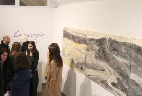 People converse and view They Come to Pay Respect: Boreal Forest As Tar Sands at the opening exhibition of Cornucopia. The piece is a 12-foot by 3.5-foot monotype made by Paper Buck, which uses used oil pastel, India ink and tusche. 