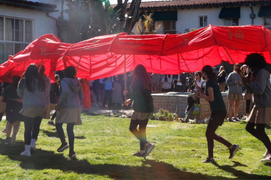 Students from the Chinese 1 class dance around the courtyard in a big red and gold dragon to symbolize good luck for the new year. The Archer community celebrated the Lunar New Year through student-led crafts, songs and dances Jan. 27.