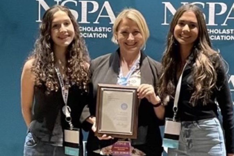 Staff Reporters Lucia Williams (25) and Surya Patil (25) and journalism adviser Kristin Taylor accept the 2022 Online Pacemaker Finalist award at the 2022 National High School Journalism Convention. This award recognized high school news sites for journalistic excellence. 