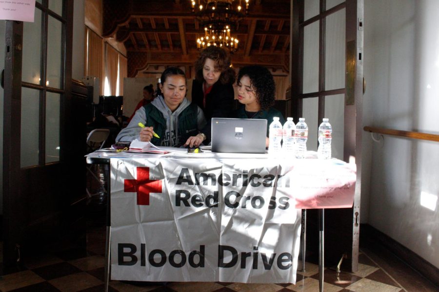 Service Squad members Malia Apor (24) and Kayla Bruce (24), as well as a Red Cross representative, highlight names and check in blood donors outside the Zeller Student Center. “Donating blood is an accessible and easy way to give back to people who need it, Service Squad member Ella Dorfman (25) said. We have a lot of people who have a lot of blood to give that’s healthy.”