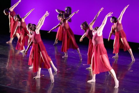 Advanced Study dancers, wearing bright red dresses, reach out their arms and point their feet as they look down on stage. "Pachinko," the dance, was based on the novel of the same name and featured the song "Run" by Joji.