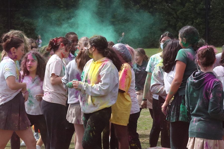 Groups of students throw and smear colored powder onto one another. The Archer community celebrated Holi and welcomed in spring March 23 on the back field for the first time by splashing this colored powder onto each others’ light-colored clothes.