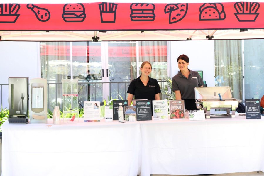 Director of Nutrition and Wellness Stephanie Dorfman and dietician Carrie Gabriel stand behind the wellness table. In addition to sampling freshly made pesto pasta, students had the chance to consult Dorfman and Gabriel on healthy eating habits.