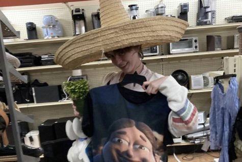 My best friend wears a tall sombrero while holding up a $4 Bolbi shirt and a fern. We found these items at the Goodwill on Sawtelle Avenue. (Photo Credit: Melinda Wang)