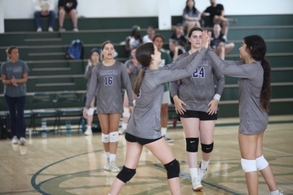 Freshmen Pheobe Measer and Chloe Ventura Ruvalcaba high-five after a point in a preseason match against St. Monica Preparatory. Archers JV volleyball team lost 0-2 against St. Monica and most recently beat the Oakwood School 2-0.
