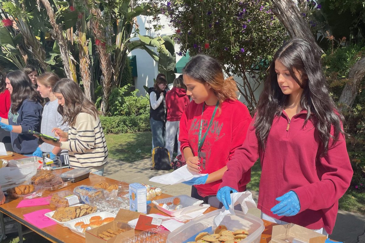 Freshmen Sloane Fitzgibbon and Shanthi Seth hand out baked goods to students in the courtyard Oct. 27. The Jewish Student Union, Artemis Center and Service Squad hosted community activities and a fundraiser to support the International Committee of the Red Cross’ relief efforts in Israel and Gaza.