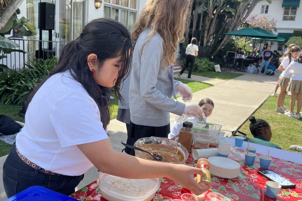 Hermanas Unidas member Maia Alvarez (’24) prepares servings of arroz con leche during the Hispanic and Latine Heritage Month festival. The celebration took place Friday, Oct. 13, during lunch and aimed to educate community members on Hispanic and Latine culture.