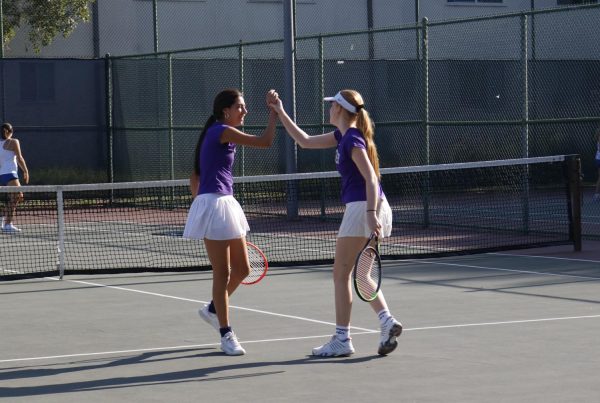 Sophomores Alex Laffitte and Oona Seppala high-five after winning a doubles match on Archer’s home courts, Barrington courts. The team is moving into the Gold Coast league next year, which means players will play different schools, including Brentwood, Crossroads and Viewpoint.