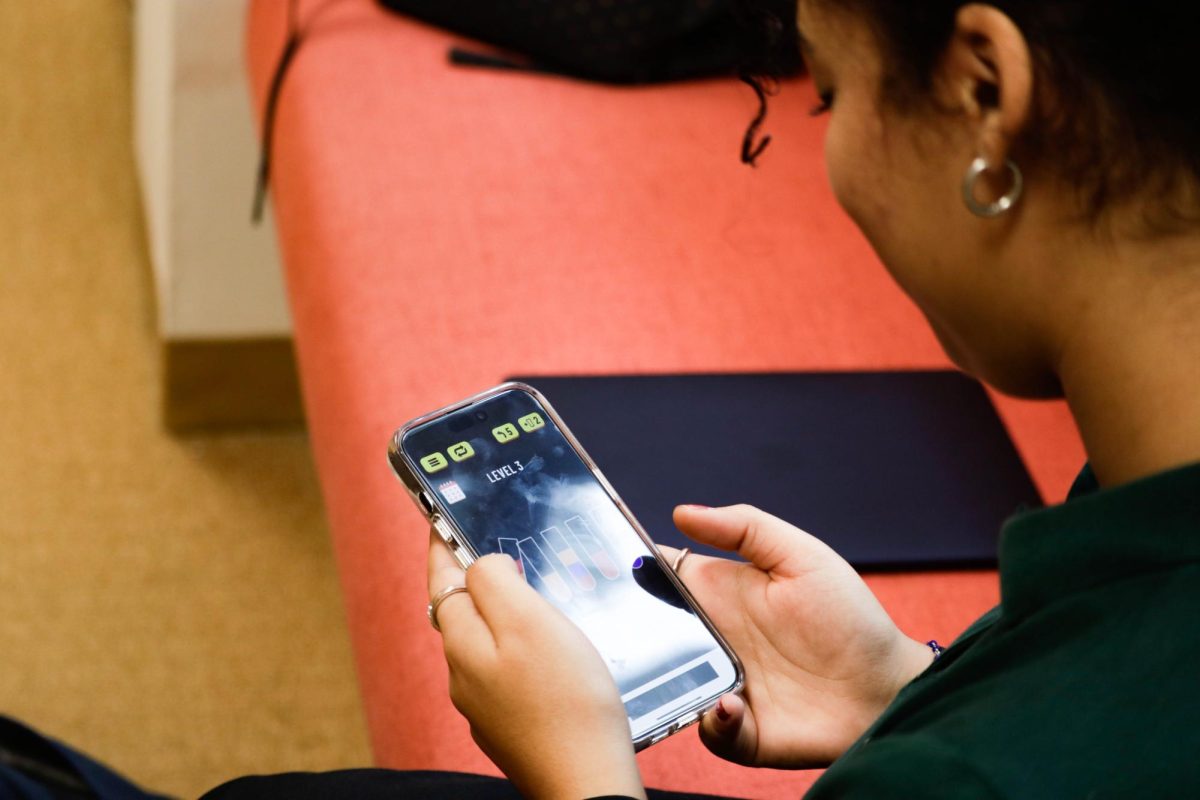 A student plays a game on their phone in the library. Upper school students can use their phone during school hours if they are not in class. People go down rabbit holes, Liv Karp (26) said. It can be at any time just scrolling and scrolling, and they lose track of time to go to bed.