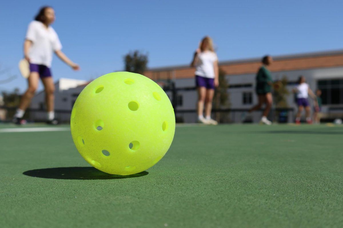 A pickleball ball lays still on the sport court on Archers back field. As a part of their fitness curriculum, 10th graders have a pickleball unit, where they practice drills and participate in round-robin style play. 