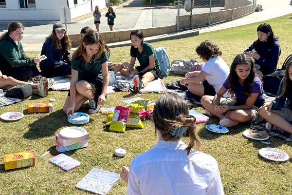 The Big/Little Archer Sisters Club members make friendship bracelets and share snacks out on the back field. The club meets every other Friday to strengthen bonds between students of all grades. Photo by Rachel Michiel.