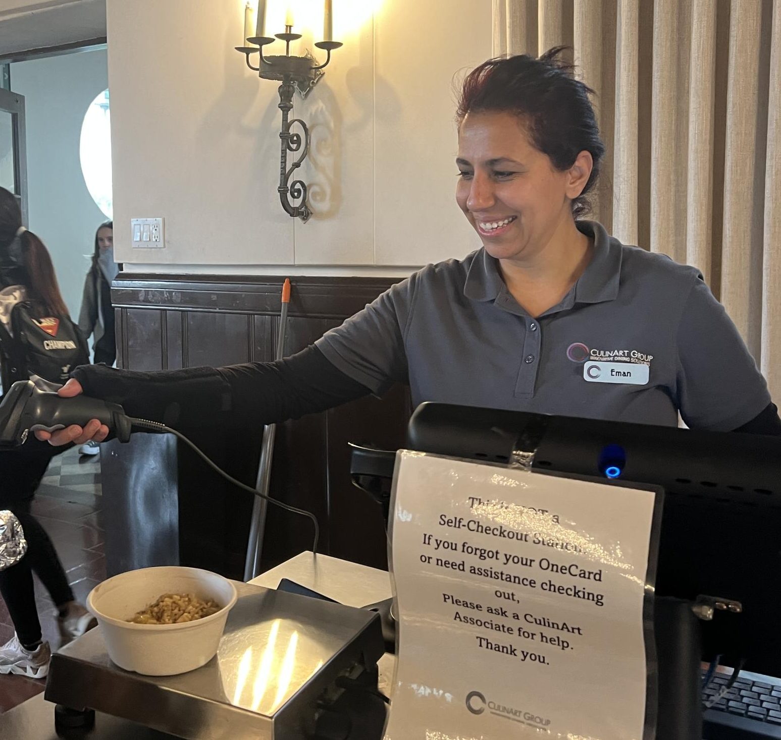 Servery worker Eman Said scans a students burger in the servery checkout during lunch. For the past two years, she has spent her days at Archer working as a cashier and her nights studying accounting at Pierce College.