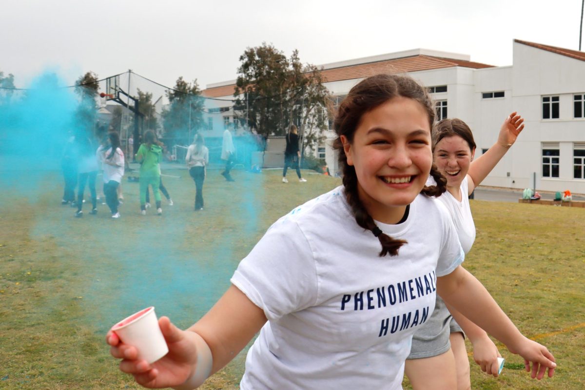 Hollyn+Alpert+%28%E2%80%9928%29+runs+while+tossing+blue+powder+into+the+air+March+22.+Students+celebrated+Holi+on+the+back+field+and+threw+colored+powder+at+each+other+at+commemorate+the+new+spring.%C2%A0%C2%A0