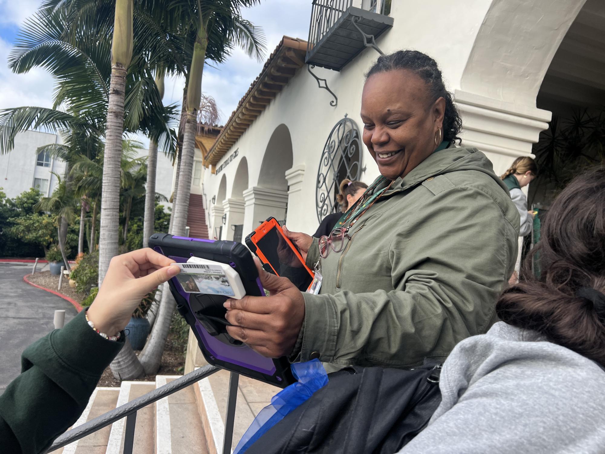 Director of Security and Transportation Yoshi Wilson scans students One Cards to mark attendance in the morning. She said she has enjoyed the all-girls school environment and has witnessed empowered women collaborating on projects and activism.