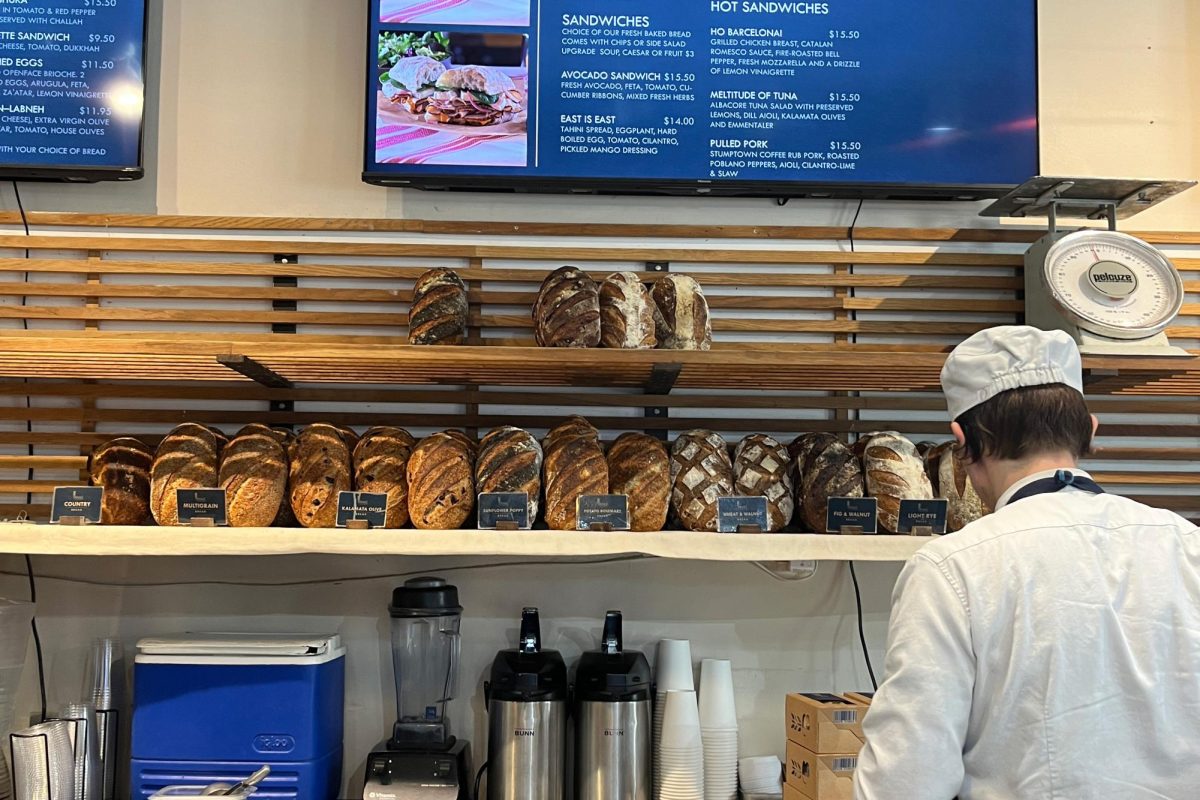 A man works at the counter at The Bread Lounge. Loaves of bread lined the shelves at this bakery that prides itself on its bountiful offerings.