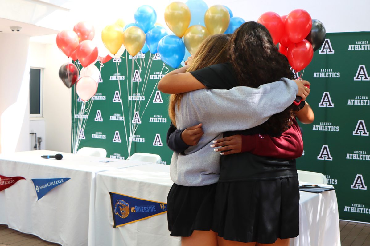 Seniors Eleanor Madley, Izzy Jeffery, Chloe Hayden and Malia Apor embrace before signing their National Letters of Intent to continue their athletic careers in college. The community celebrated their signings April 17, and the Class of 2024 has the most college athletic commitments in Archer history. 