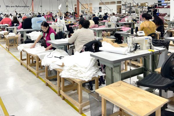 Workers sew together intricate pieces of white fabric in a production line at Reformations at the original factory in Vernon, California. In 2020, the brand was awarded with a Sustainability Quality Award of Excellence for Social Responsibility. 