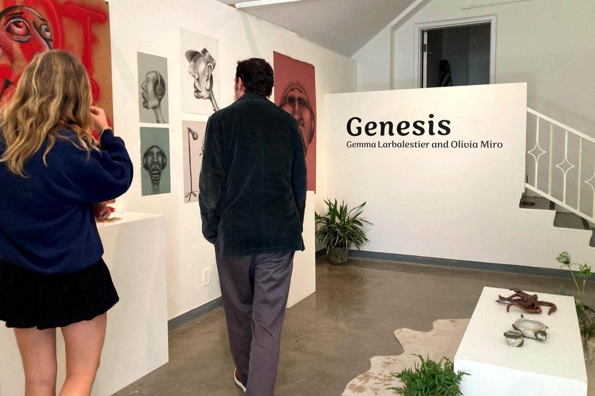 Senior Gemma Larbalestier shows world language teacher Juan Carlos Moraga Vidal her artwork, which combines the human experience with music. Larbalestier and Olivia Miro’s senior show, “Genesis,” took place May 1 in the Eastern Star Gallery.