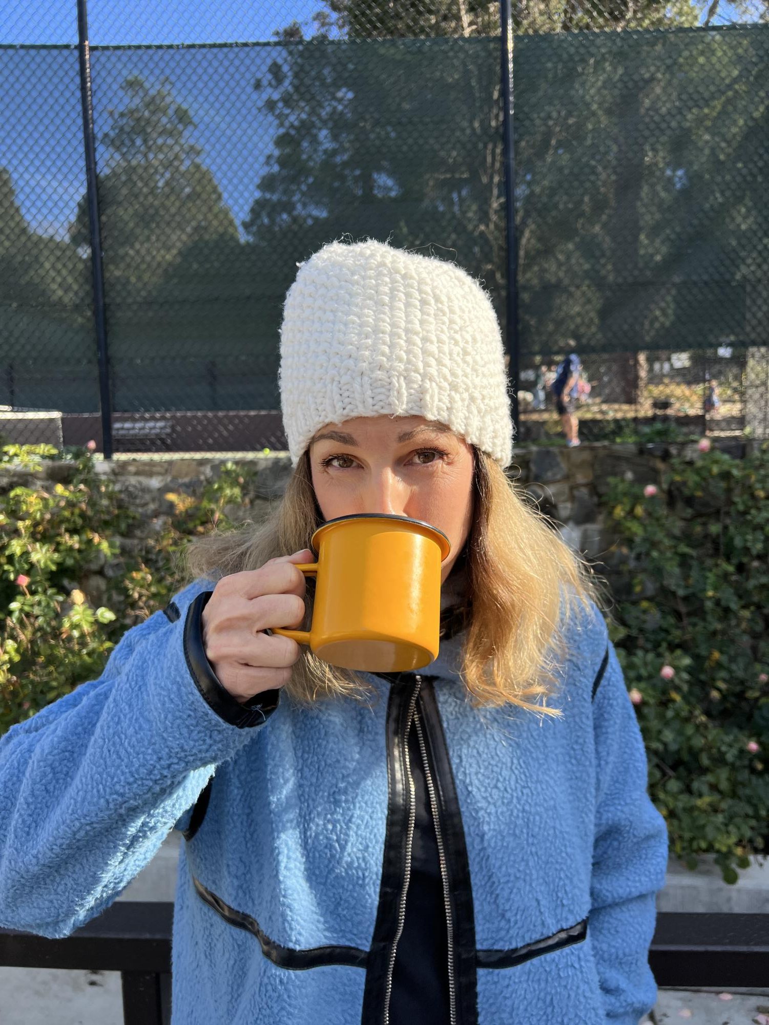 My mom sips a steaming mug of coffee on a chilly day. With plummeting temperatures comes the resurgence of fuzzy beanies and plushy coats, and their endless designs allow for many styling possibilities.