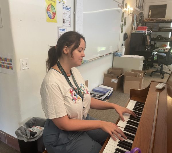 Choir and a cappella Director Bri Holland practices a song at the piano in the choir room. "I'm excited to be in a space where I can see students for up to seven years at a time," Holland said. "I'm excited to cultivate that relationship."