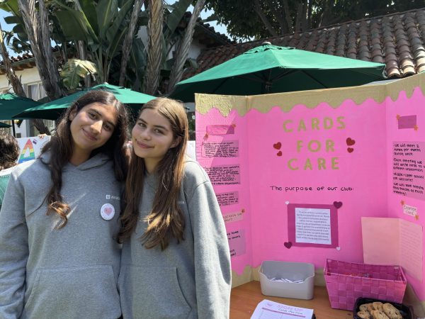 Leaders of Cards for Care club Sophie Shafipour ('27) and Olivia Toborowsky ('27) smile in front of their poster during the Club Fair Sept. 26. Members of their club write letters to isolated communities to spread kindness and positivity.