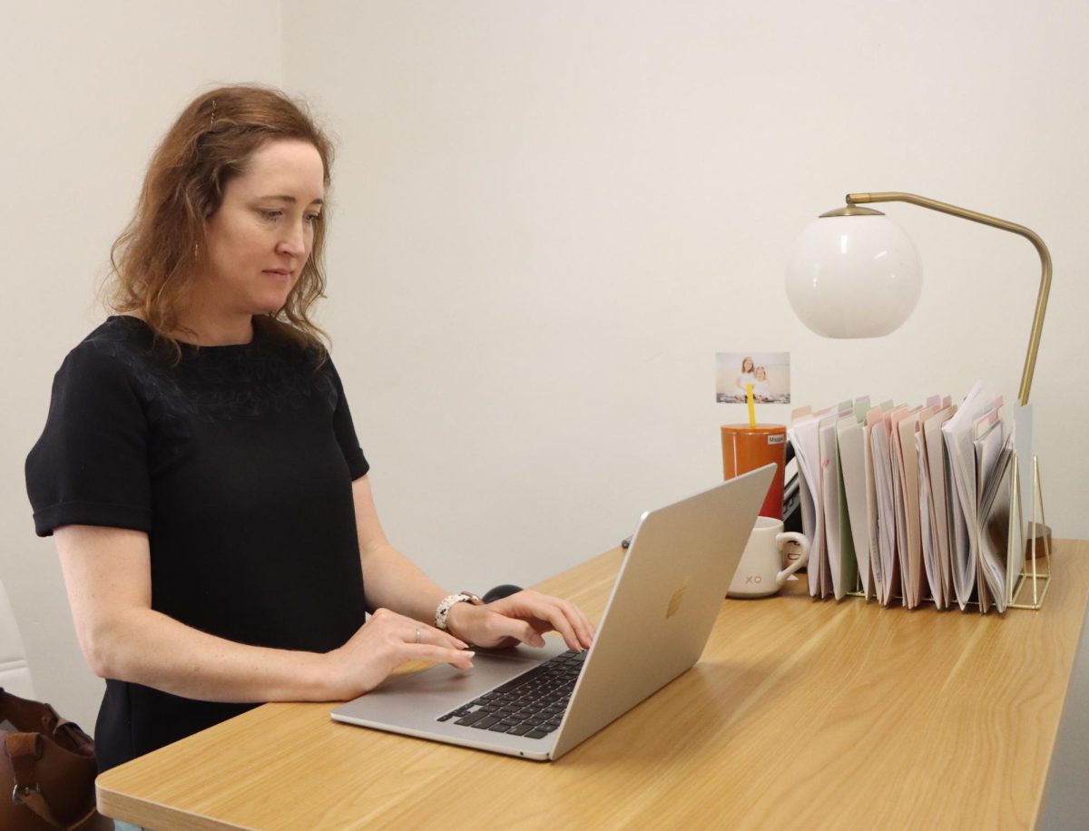 Upper School Director Maggie Cenan works at her new desk in the administrative hallway. She accepted the role this summer after serving as the math and computer science department chair.