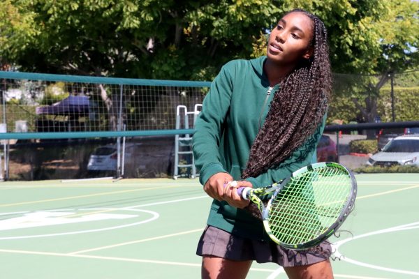 Swinging her racket, junior Isley Bonney practices her tennis swings out on the back court. Bonney plays on the JV tennis team and said she has grown immensely since she started tennis in ninth grade. 