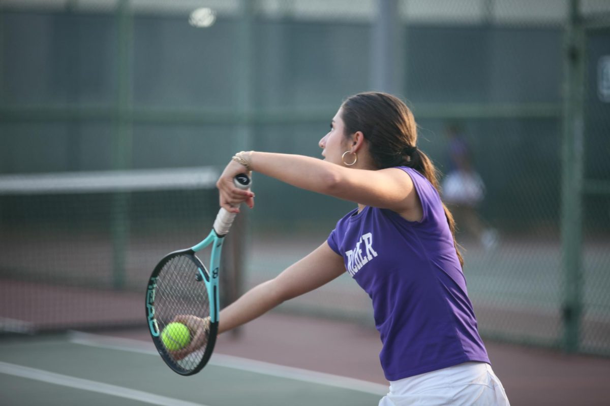 Sophomore Abigail Weiner serves the ball to her opponent during a match against Windward School. The varsity tennis team placed fourth in their first year in the Gold Coast League. (Photo by Archer Athletics.)