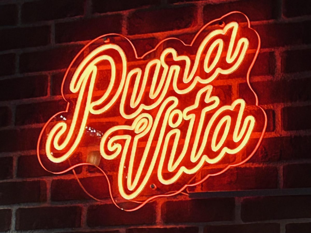 Pura Vita sign lights up the restaurant above the bar. Pura Vita's locations are in West Hollywood and Redondo Beach. (Photo Credit: Lily Kaplan)