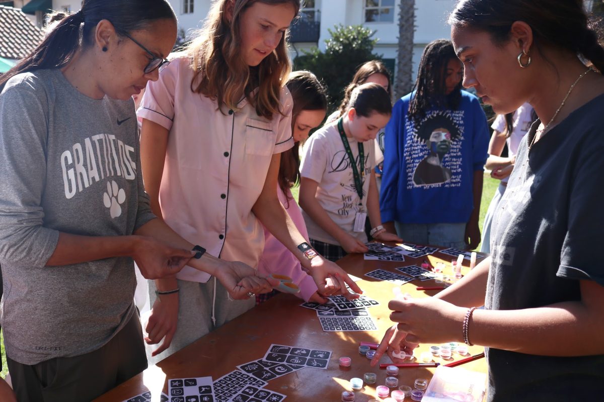 Community members pick out stencils for temporary glitter tattoos Friday, Nov. 1 as a part of Archer's lunchtime Día de Los Muertos celebration. 