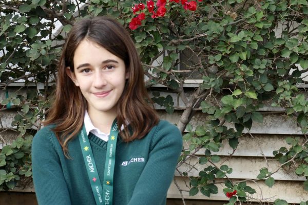 Seventh grader Nina Tooke smiles while sitting on a bench on Archer’s front veranda. Recovered from her injury, Tooke said she is ready to jump back into her daily routine. “Nina has really just led the confidence charge,” Choir and A Cappella Director Bri Holland said.