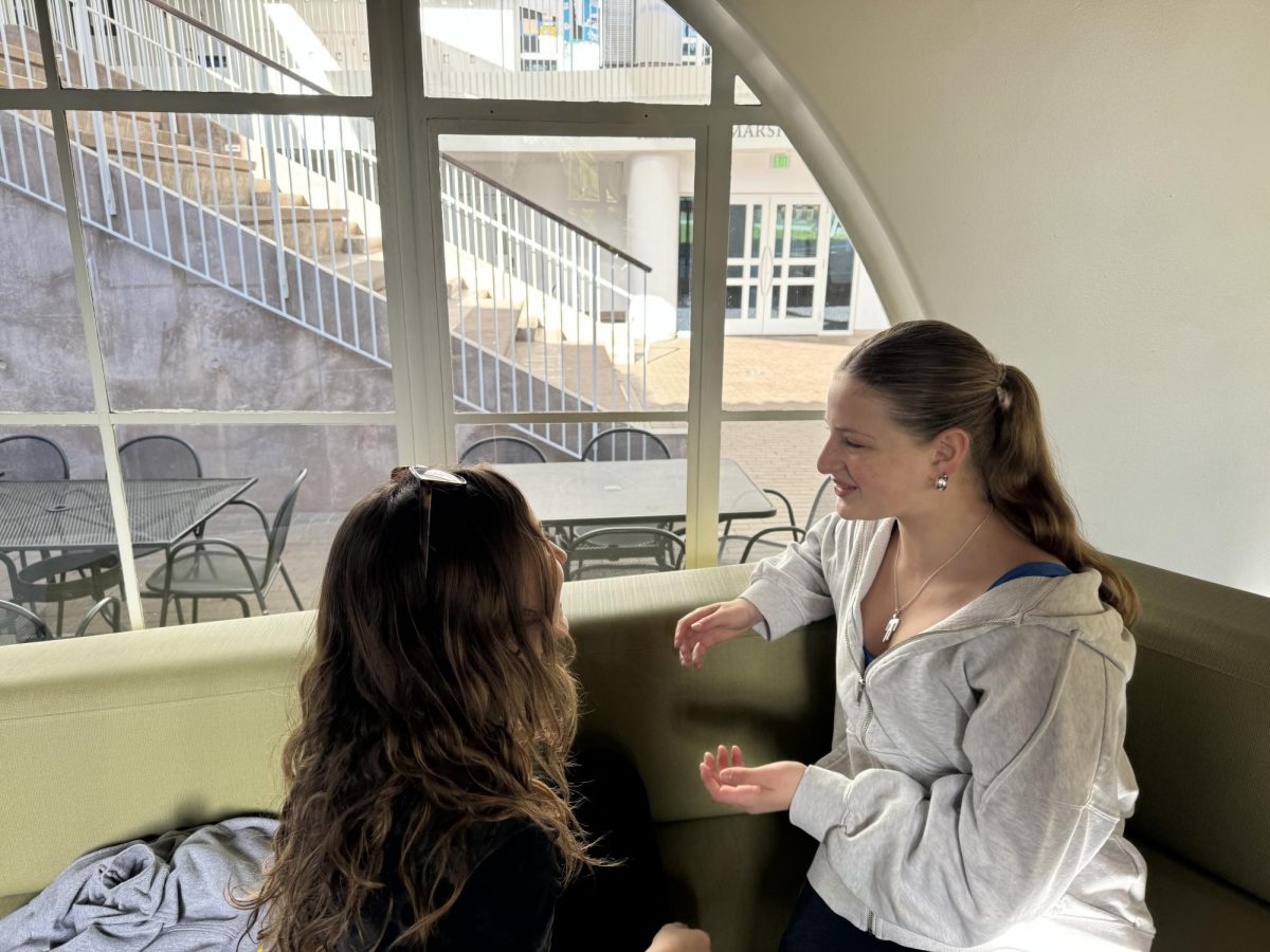 Olivia Broock ('27) talks to her friend on a couch. In an era where a teenagers are constantly overwhelmed with work and other activities, talking to others is an effective tool to manage stress. 