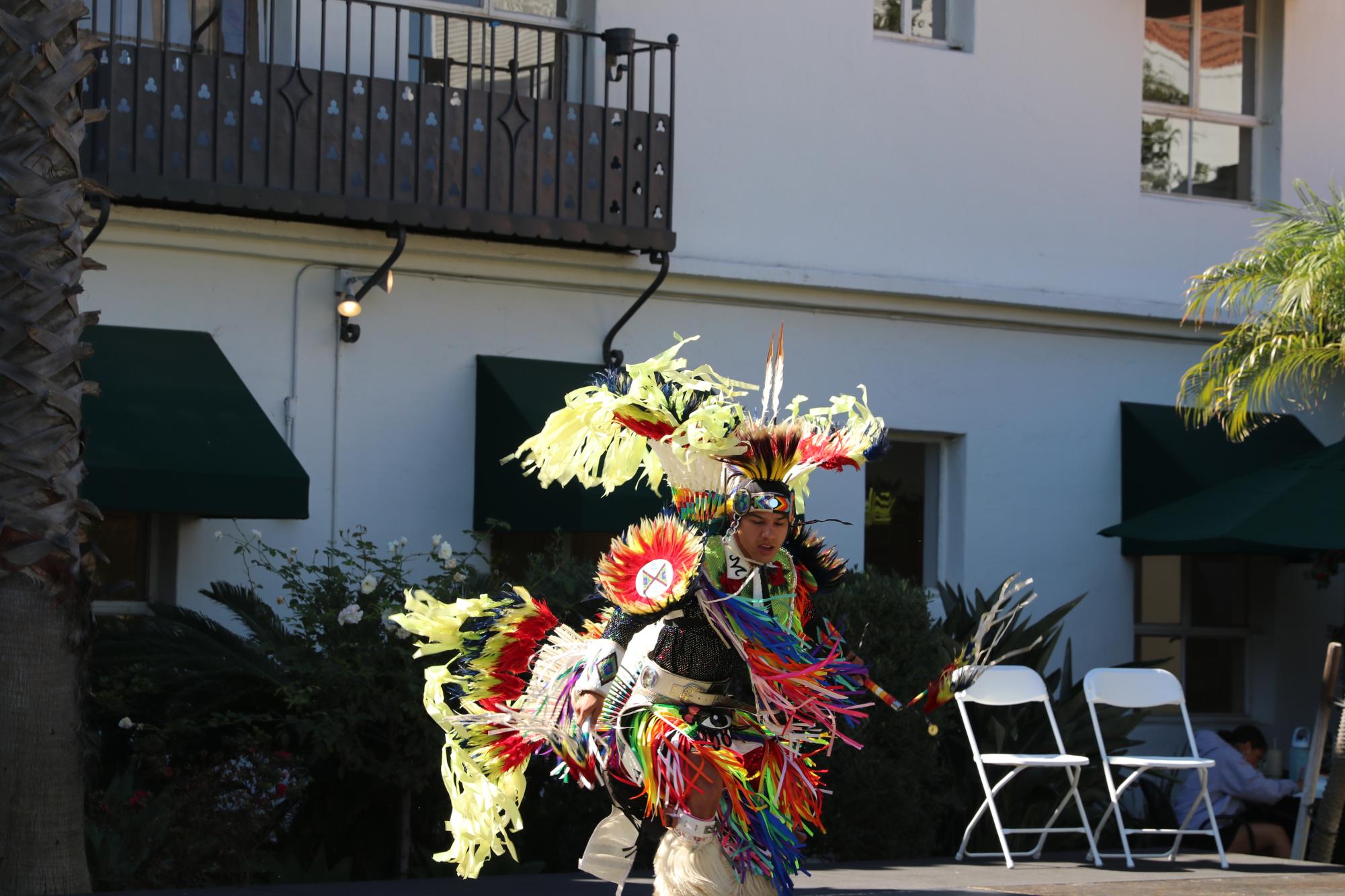 Performer Micheal Tiger performs the Men's Fancy dance wearing his regalia. Micheal described the components of his regalia by saying that the "bustles are made out of turkey spikes, hackle feathers, porcupine quills and bead."