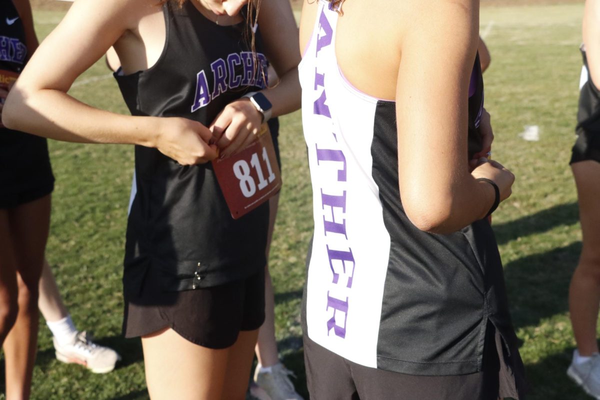 Athletes attach their bib numbers to their uniforms before the race starts. These numbers allow coaches and organizers to track the runners during a race, assist with timing and help with identification. 
