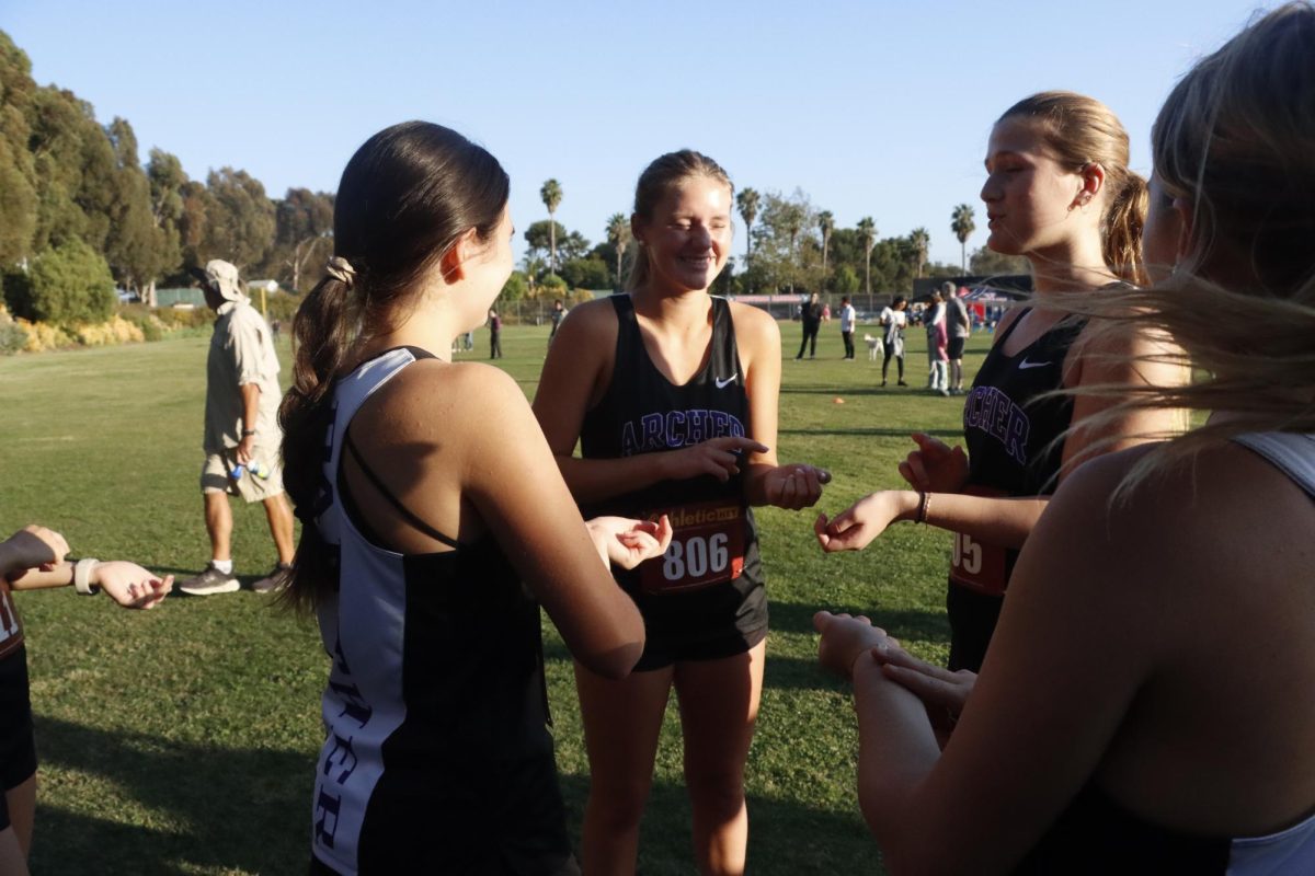 Co-captain Katie Ray McKillop (‘27) leads her team through a pre-race ritual. “I taught them about this thing called tapping, which is when you tap all of your pressure points to calm your nervous system before a race,” McKillop said. “I tell them they're gonna do great, I try to motivate them and I also bring snacks.”