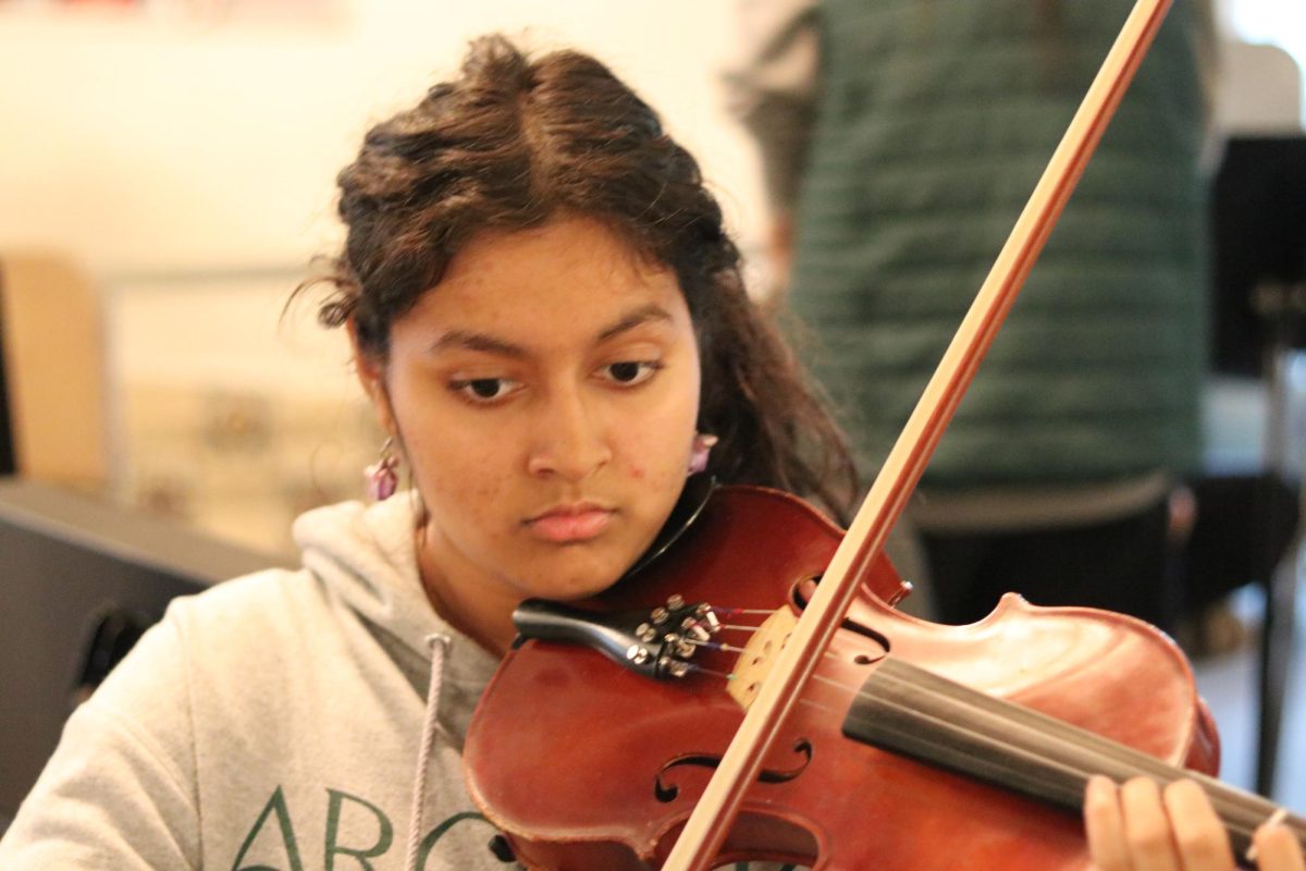 In after-school orchestra rehearsals, Malvkia Ganapathy (‘28) practices her part in the song Howl's Moving Castle on the violin for the upcoming winter concert. Orchestra rehearsals, led by Hannah Murray, take place once a week, every Wednesday. Ganapthy sits second chair in the first violins section. “The community is so tight-knit,” Ganapathy said. “I have really enjoyed being a part of the community and performing twice a year.” 