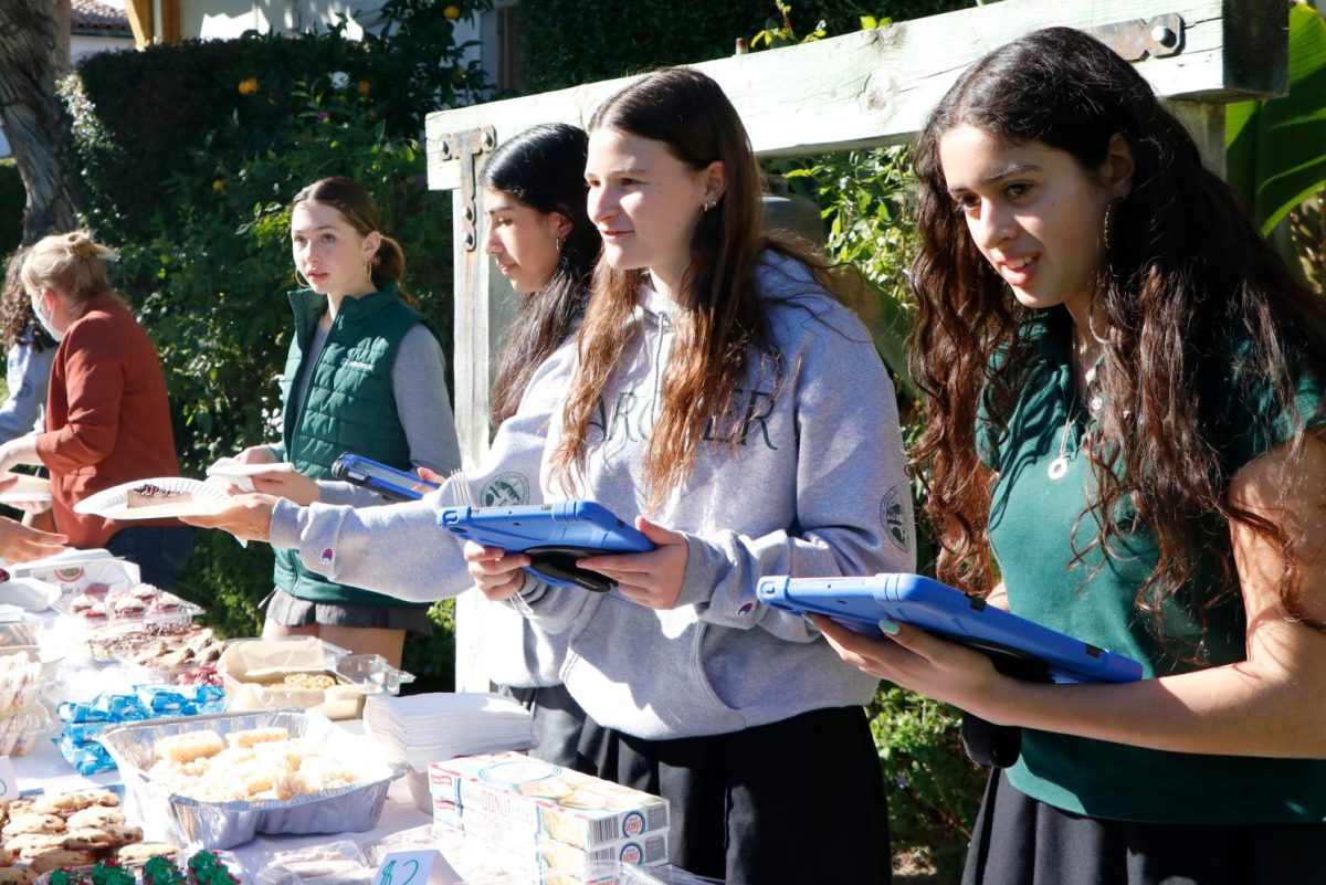 Sarah Mzoughi (’28) uses an iPad to help students pay for baked goods to support the fundraiser. Mzoughi said her role in the club has allowed her to see the impact of providing resources to underprivileged communities. “CHLA provides services to a lot of underfunded communities,” Mzoughi said. “It’s our responsibility as privileged young women to give back, whether it’s by making goods or raising money.” 