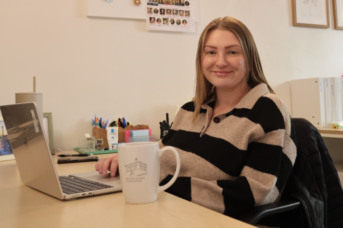 Madison Florian poses for a photo as she sits at her desk. Florian, a former Archer student, has returned to be the school nurse. “This is where I spent seven years of my life,” Florian said. “I’m very happy to be back.” (Photo by Lila Stotland)