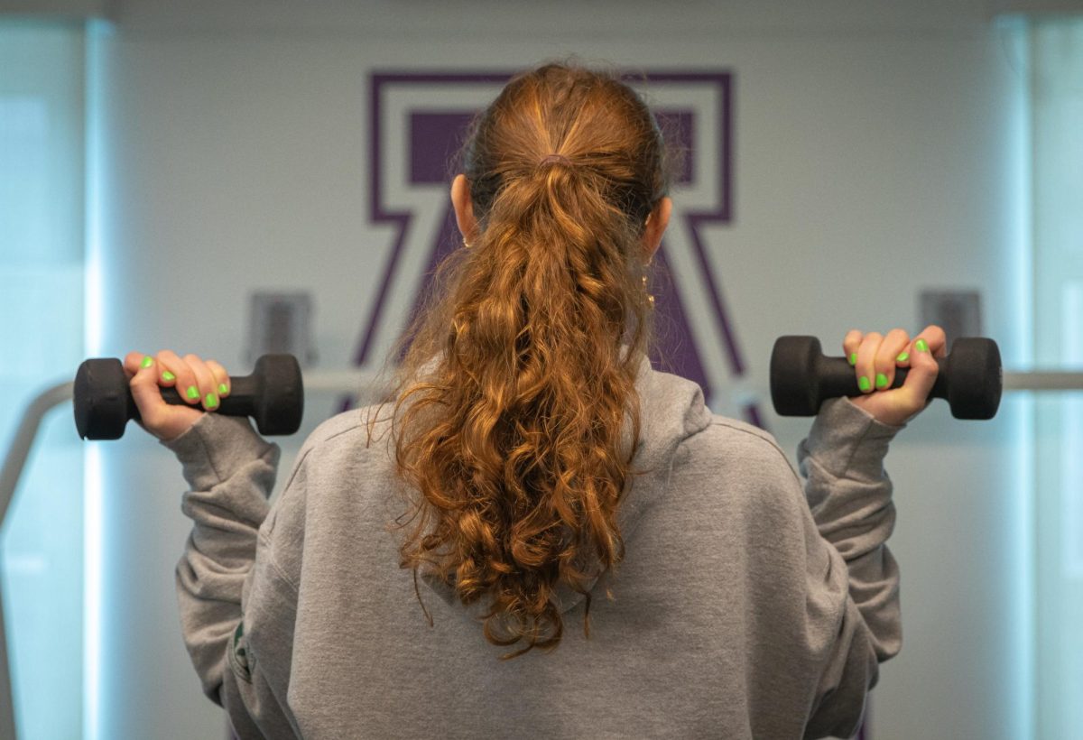 Holding weights, Camden Forster ('27) poses in the Training Center. With the new year came an increase in healthy habit goals amongst teens. However, social media's influence, peer pressure and body image insecurity can change how healthy these goals really are. 