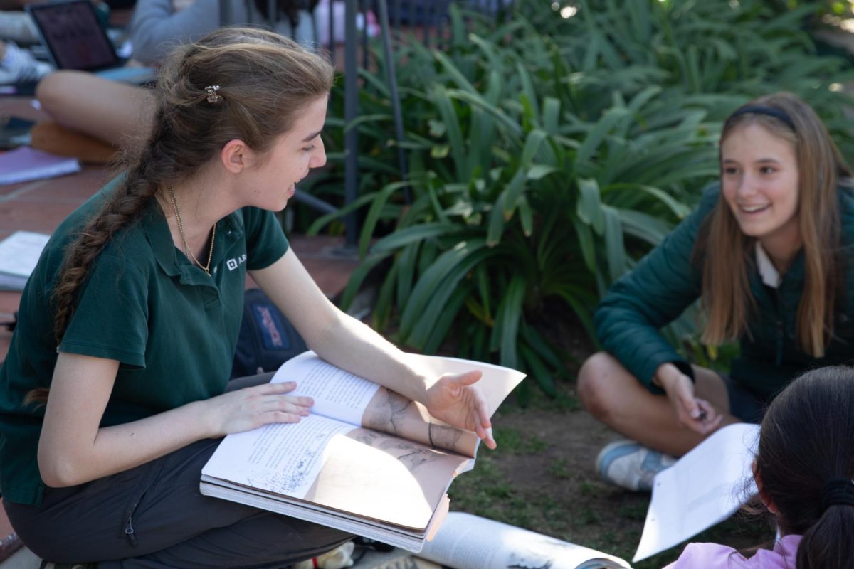 Senior Vivianne Arnold converses with seventh grader Sloane Adamson as she completes an assignment. Inter-grade connection can also be a great way to foster meaningful interactions with those we may not see every day. 