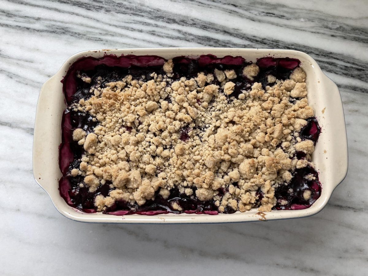 A berry cobbler sits on my countertop. This cobbler was made with one of the recipies featured in this article, and it was enjoyed alongside a scoop of vanilla ice cream. 