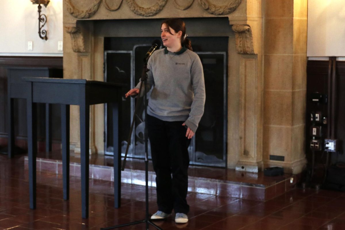 Stella Leland ('26) stands in front of the podium reciting her poem, “Mountain Dew Commercial Disguised as a Love Poem,” by Matthew Olzmann for the first round of Poetry Allowed. This is Archer's first year doing Poetry Allowed after ending its particaption in Poetry Out Loud.
