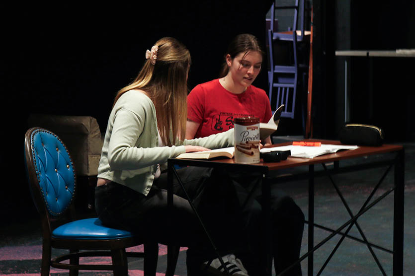 Sitting at a desk reading “The Crucible,” Olivia Broock (‘27) and Stella Leland (‘26) perform their scene from “John Proctor is the Villain.” Broock played Nell Shaw, a thoughtful and observant student, while Leland portrayed Mason Adams, a student who often misunderstands situations. Broock said the scene highlighted tension and unease within the school community. "There is a lot of discourse and a lot of people are really uncomfortable with what's happening because they live in such a rural area,” Broock said. “More parallels get drawn between calling people witches and criticism with women who are involved with the #MeToo movement.” 