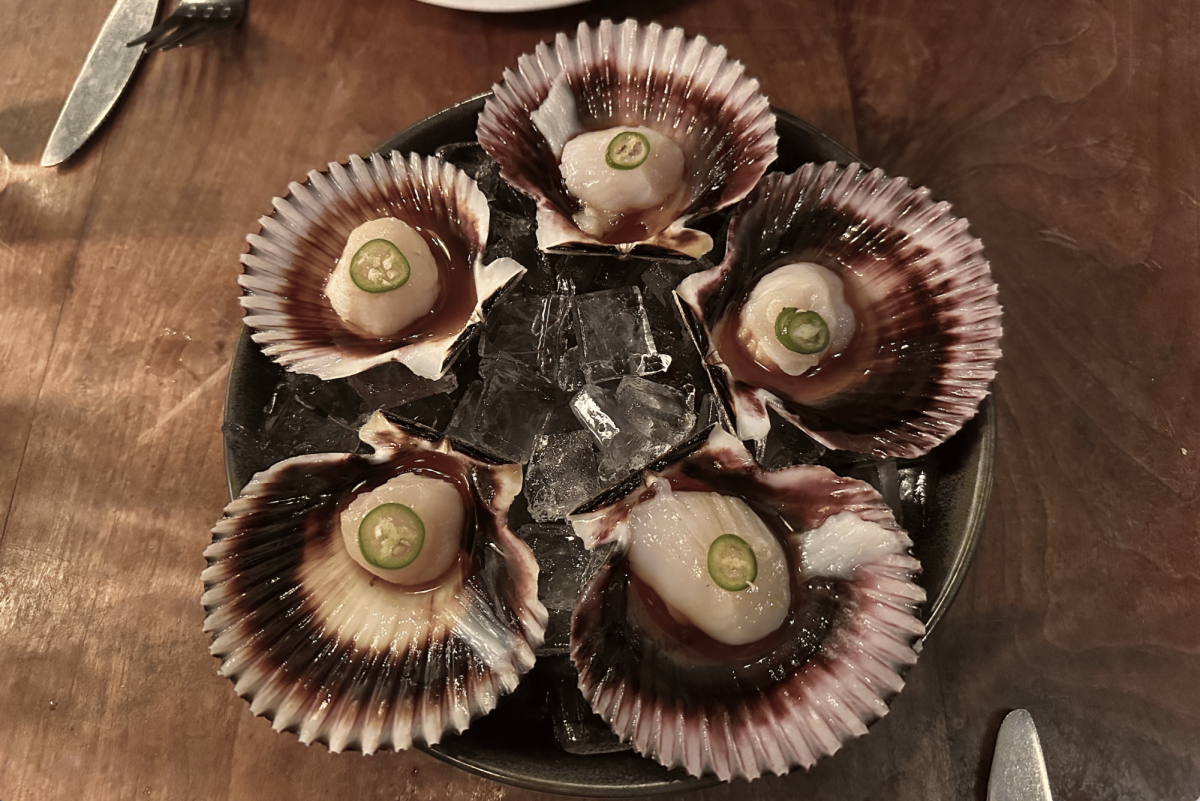 Dudley Market's Peruvian Scallops are displayed on a plate in seashells and topped with jalapeño. Dudley Market is a seafood restaurant in Venice tucked away on a quiet residential street just steps from the beach. Known for its fresh raw fish, inventive vegetable dishes and its famous burger, the menu is designed for sharing.