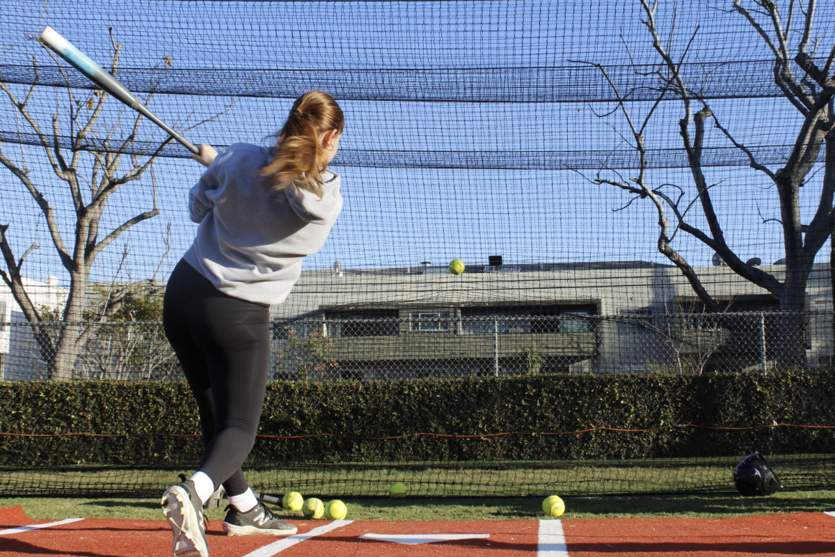 Arianna Borstein ('27) practices her swing against the net. Softball practice on February 11 had consisted of a rotation around various stations working on batting. "Practice, for me, is a time that allows us as a team to celebrate our wins, uplift one another, and create an environment made for mistakes and growth," Borstein said.