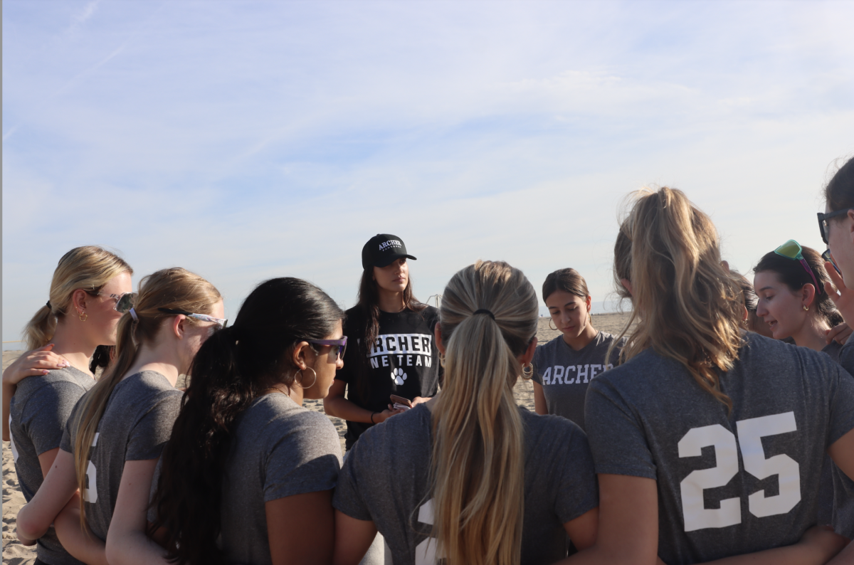 Beach volleyball coach Eleonore Johansen gives a pep talk to her team before they begin their game. Sources say that being coachable isn't merely about nodding at feedback while mentally drafting your rebuttal; it's about the discipline of choosing curiosity over control. "My coaches always know when to give me feedback," Vienna Gentin ('29) said, "but they also know when to let me be and figure it out on my own." 