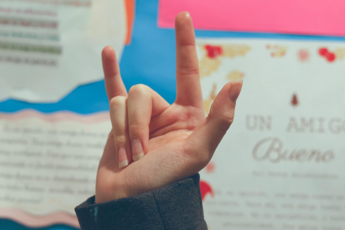 A student makes the American Sign Language sign for "I Love You" in front of the language hallway. According to the CDC, about 34 million children worldwide have some form of hearing loss, which makes learning ASL so important. 