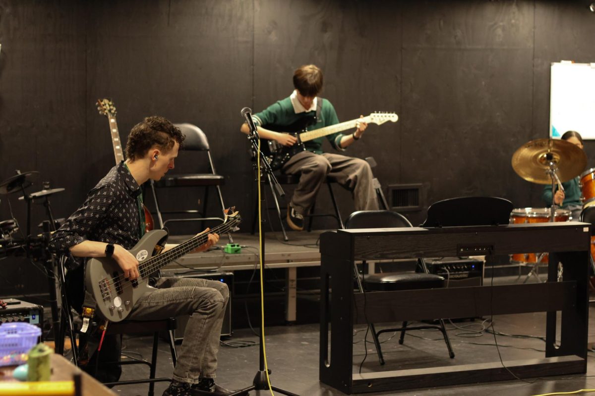 Arts teacher Chris Kapica and Mimmy Goetsch ('31) play guitar together during a Jam Session in the Black Box Theatre. "It's a fun mix of a lot of things," Kapica said, "but at the end of the day, people are singing along, people are are having fun, people are making noise and that's just reveling in the joy of music and that's the whole point."