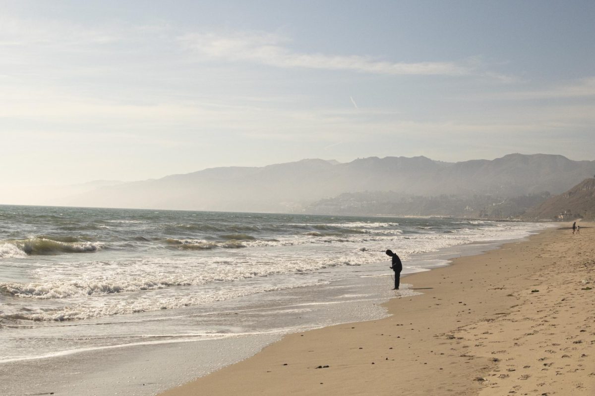 A child stands at the shore of Will Rogers Beach State Park, located in the Pacific Palisades, an area impacted by the Los Angeles Fires. Research reveals that many parts of the ocean were also impacted. However, there are still gaps in the available data, according to Heal The Bay’s Director of Science and Policy Kerry Nickols. “We learned that there actually are … no guidelines about recreational exposure to some of these chemicals in the ocean,” Nickols said. “One of the biggest problems is that people were like, ‘is it safe to swim?’… We had to say, ‘Well, we don’t know if it’s safe to swim because there are no public guidelines.’”